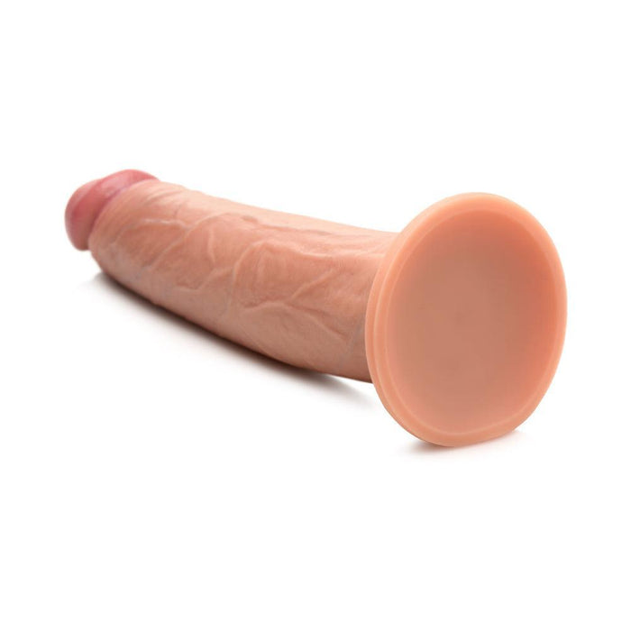 The Jock Real Skin Thick 8.5 Inch Medium Tone Silicone Suction Cup Dildo, featuring a realistic design and flat base, rests on a white surface.
