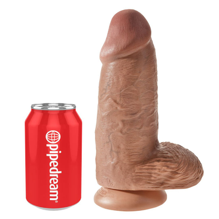 The King Cock Chubby Thick 9 Inch Suction Cup Medium Tone Dildo, featuring a pronounced head, textured veins, and sturdy suction base, stands upright next to a red "pipedream" soda can for size comparison.