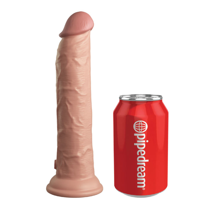 The King Cock Elite Long 9" Vibrating Dual Density Silicone Dildo with Remote, featuring a realistic flesh tone and textured surface, stands upright beside a red "pipedream" soda can for size reference.