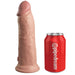 The King Cock Elite Thick 8 Inch Vibrating Dual Density Silicone Dildo stands upright beside a red soda can marked "pipedream" for size comparison. This lifelike, strap-on compatible toy offers realistic detail and versatility against a white background.