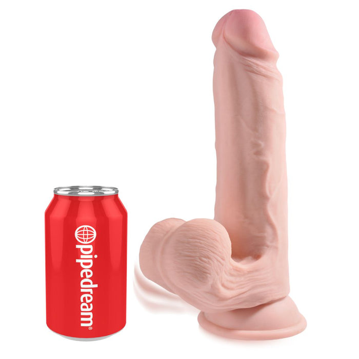 The King Cock Plus Swinging Balls Realistic 9 Inch Light Tone Dildo stands upright, featuring lifelike testicles and a sturdy suction cup base, shown next to a red "pipedream" soda can for size comparison.