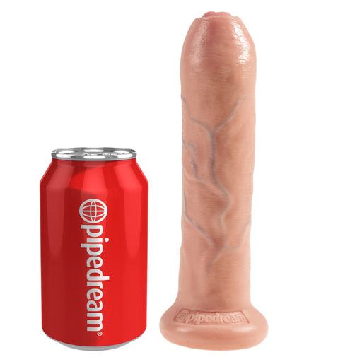 The King Cock Uncut 7 Inch Light Tone Suction Cup Dildo with Moving Foreskin stands upright beside a red "pipedream" soda can, offering a clear size comparison between the realistic dual-density toy and the can.