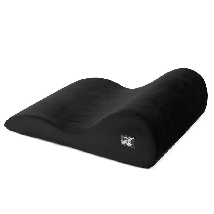 The Liberator Hipster Intimate Positioning Support Sex Cushion is black, ergonomically contoured with a wave-like shape and side label, designed for comfort, full-body support, and enhancing intimate experiences.