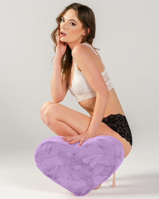 Dark haired model crouched down holding Liberator Faux Fur Heart Wedge Sex Positioning Cushion - Purple