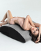 Caucasian female model laying on Liberator Scoop Rocker Wedge with Cuffs - Grey
