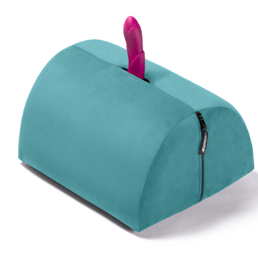 The Liberator BonBon Rideable Sex Toy Mount is a teal, semi-cylindrical cushion with a zippered side and an opening on top to hold your favorite toy upright for hands-free play.