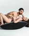 Caucasian couple laying on Liberator Scoop Rocker Wedge with Cuffs - Grey