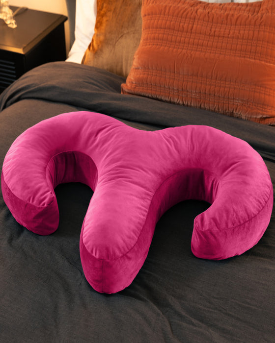Liberator Arie Toy Mount Spooning Pillow - Pink on bed with brown comforter 