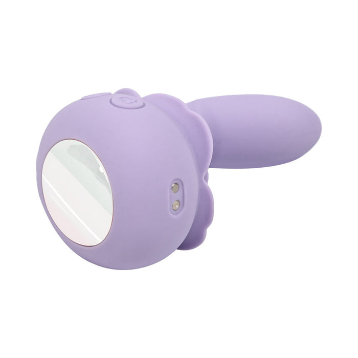 The Lilac Licks Clitoral & G-Spot Vibrator with Tongue Tease, a purple silicone device with a curved handle, round reflective end, and two metallic contact points, is displayed against a white background.