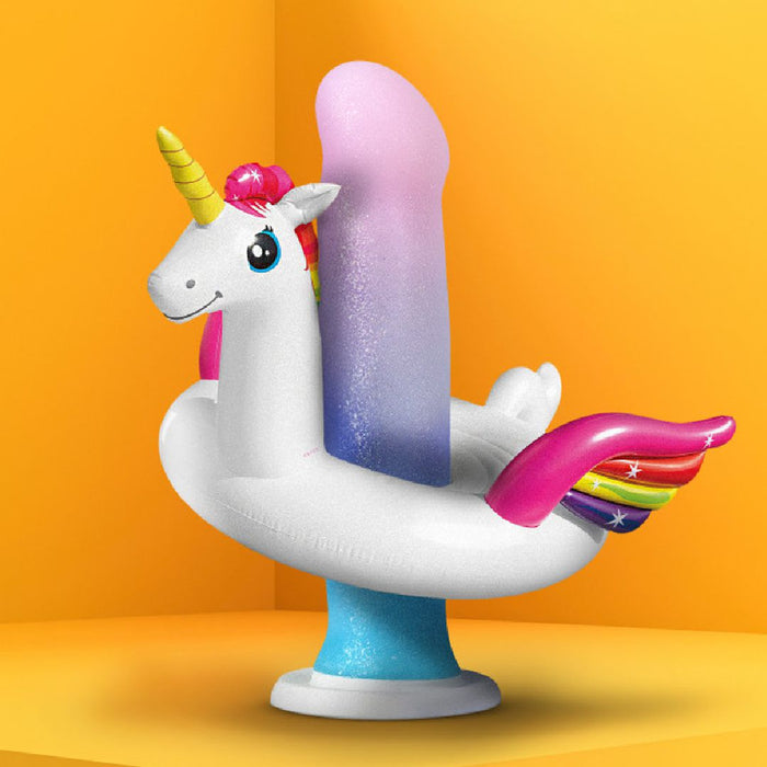 A whimsical inflatable unicorn pool float surrounds the Lucky Sparkle Lightly Textured 8 Inch Silicone Suction Cup Dildo, featuring a rainbow gradient and unicorn horn shape, crafted from body-safe silicone, against a bright yellow background.