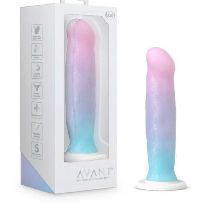 The Lucky Sparkle Lightly Textured 8 Inch Silicone Suction Cup Dildo, in pastel pink, purple, and blue gradient, stands upright beside its white Avant box featuring product details and a clear window to showcase the dildo.
