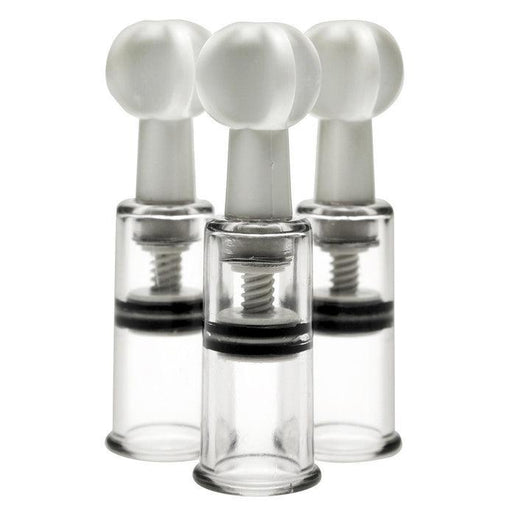 Three clear plastic cylindrical Max Twist Triplets Nipple And Clit Suckers by XR Brands, each with a white knob on top, are positioned upright and aligned in a triangular formation. The mechanisms inside the suction cylinders are visible, including the screw-like components used for suction.