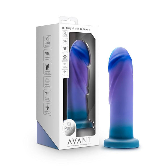 The Midnight Rendezvous Textured 7.5 Inch Girthy Blue Silicone Dildo stands upright by its Avant-branded box. This body-safe silicone toy features a realistic shape, suction cup base, and is strap-on harness compatible.