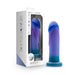 The Midnight Rendezvous Textured 7.5 Inch Girthy Blue Silicone Dildo stands upright by its Avant-branded box. This body-safe silicone toy features a realistic shape, suction cup base, and is strap-on harness compatible.