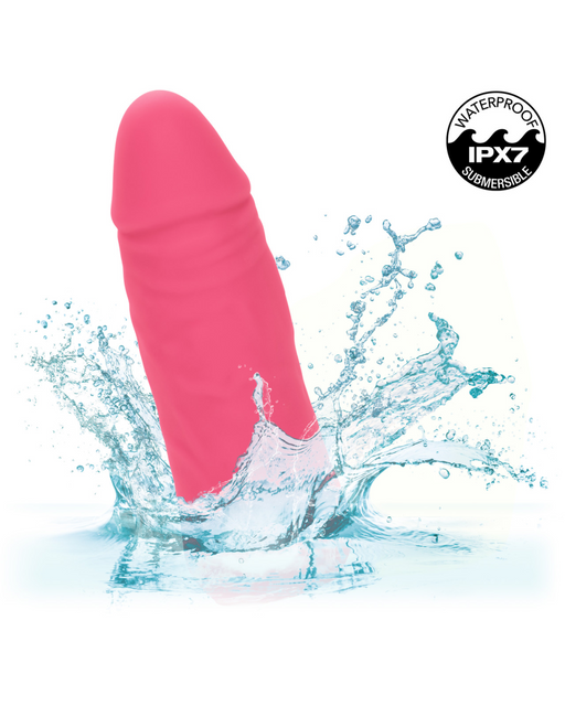 A pink, phallic-shaped waterproof Vibrating Stud Mini Cock Shaped Bullet Vibrator - Pink from CalExotics splashes in water, crafted from liquid silicone. The label in the top right corner indicates it is IPX7 submersible.