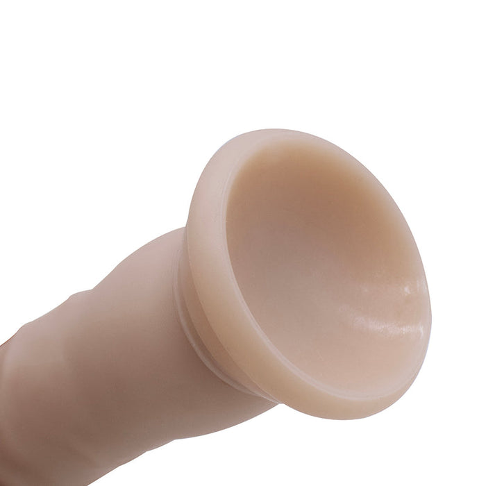 A close-up of the My First Willy Small Realistic 5 Inch Light Tone Silicone Dildo with a rounded suction base, photographed against a white background.
