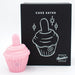 The pink Cake Eater Clitoral Stimulator Tongue Vibrator stands beside its black box packaging, which displays a white line drawing and the product name, promising indulgent clitoral stimulation.