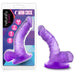 A purple, realistic 4-inch suction cup dildo, Naturally Yours Small Realistic 4 Inch Purple Mini Dildo, is shown outside its packaging with product features on a geometric background—ideal as a beginner strap-on.
