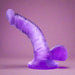 The Naturally Yours Small Realistic 4 Inch Purple Mini Dildo, made of translucent silicone with lifelike details and a sturdy suction base, stands upright against a matching purple background—ideal for beginner strap-on play.