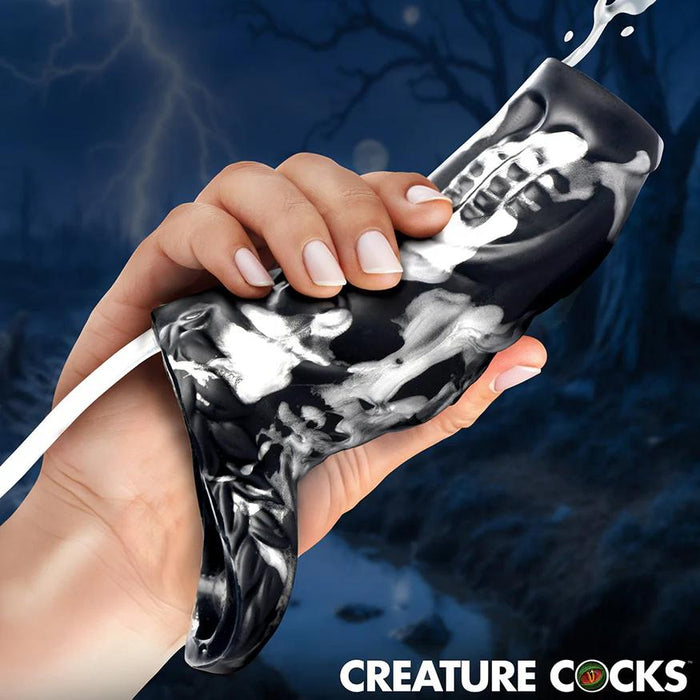 A hand holds the Night Prowler Squirting Penis Enhancer, black and white marbled, with liquid squirting from the tip as a dark forest looms behind. "CREATURE COCKS" appears boldly at the bottom.