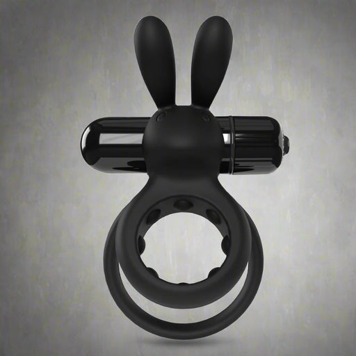 The O Hare Deep Rumbling Vibrating Beginner Couples' Cock Ring, a black silicone adult toy with bunny ears and a cylindrical attachment, is displayed against a plain gray background.