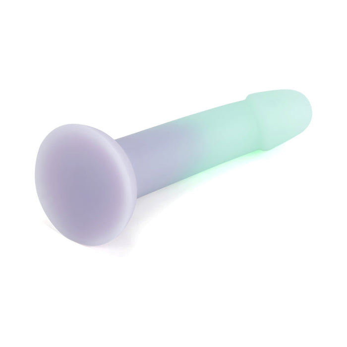 The Ombre Curve Smooth Slim Liquid Silicone 6 Inch Dildo features a glow-in-the-dark pastel ombré design, a suction cup base for hands-free play, and smooth light purple and green coloring, shown on a white background.