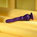 The Wiggle It Silicone Wiggling Vibrator with Suction Cup Base, featuring a purple, ergonomic design and textured grip, is displayed on rolled yellow paper against a yellow background.