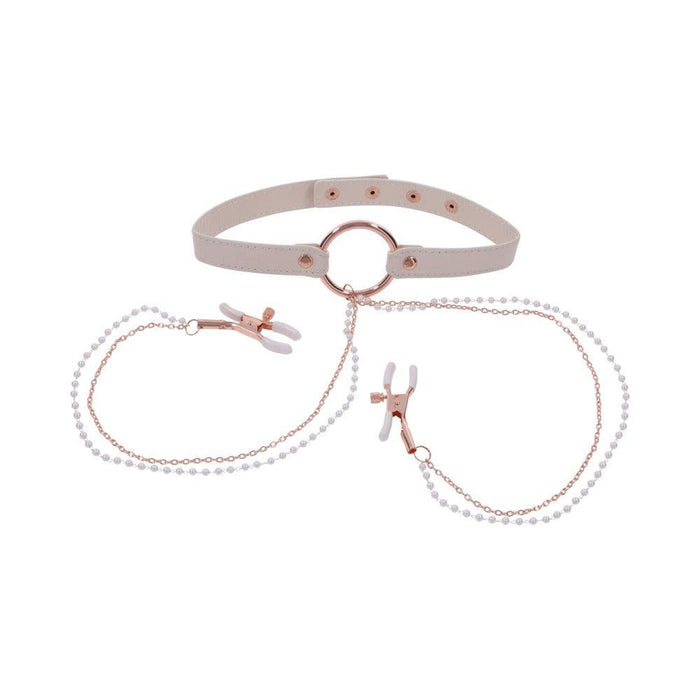 The Peaches 'n Cream Collar and Nipple Clamps by Sportsheets features a beige choker with a central ring that serves as an adjustable collar, linked to two nipple clamps via delicate pearl-embellished chains. The clamps are equipped with white silicone tips, and the design is highlighted by rose gold hardware accents.