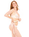 A smiling woman with long red hair in light lingerie stands against a white background, holding her Peaches 'n Cream Flogger, its playful white and red tails resting lightly at her hip.