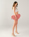 Dark haired model holding Liberator Faux Fur Heart Wedge Sex Positioning Cushion - Pink