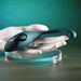 A white sculpted hand displays the Pinpoint Perfection Flexible Slim Vibrator—a sleek, teal, bendable toy made of body-safe silicone with a power button and black accent—set against a green gradient background.