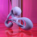 The Playboy Fantasy Cock Cage is a smooth, abstract silicone sex toy with twisting, looped shapes, featuring vibration and USB recharge. It stands out in pink and purple hues with glossy, reflective highlights for a modern look.