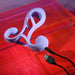 The Playboy Fantasy Cock Cage is a purple, vibrating silicone toy with an ergonomic design, USB rechargeable and perfect for couples, shown on a translucent red and orange surface.