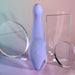 The Playboy Nice to Meet You Powerful Thrusting Vibrator with Handle, in lavender, stands upright on a pastel gradient background, accented by clear geometric acrylic shapes. Three control buttons are visible on its handle.