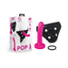 The Pop Strap on Dildo & Harness Set in Pink Silicone (5 inches) is shown with a pink dildo, black harness, and ring beside the packaging featuring product images and details.