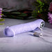 Lavender silicone phallic vibrator with a finger loop and magnetic USB charging cable on a stone surface.