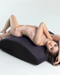 Caucasian female model laying on Liberator Scoop Rocker Wedge with Cuffs - Plum