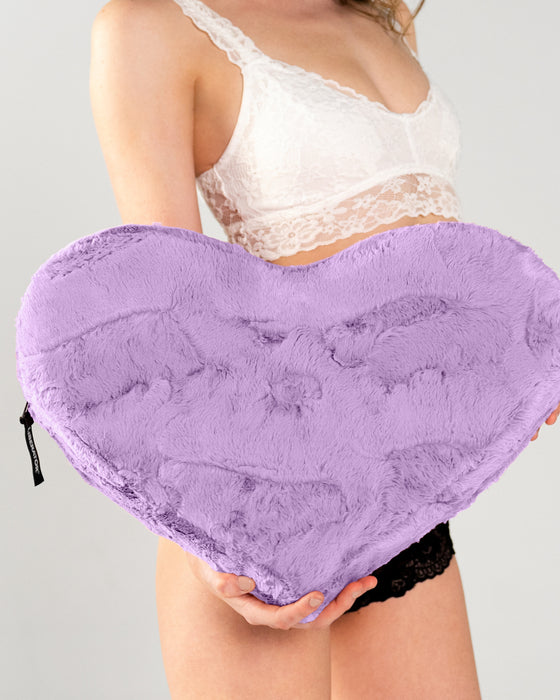 Liberator Faux Fur Heart Wedge Sex Positioning Cushion - Purple held by model in white and black lingerie 