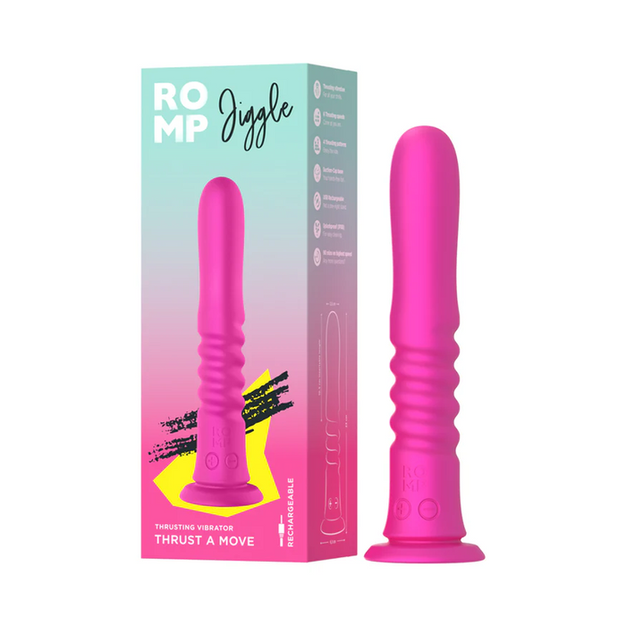 A pink ROMP Jiggle Thrusting Vibrator with Suction Base stands upright next to its colorful packaging, which displays the product name and highlights its hands-free use and innovative features.