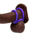 The Romp Remix Cock Ring Trio features two body-safe silicone cock rings—one on the shaft and one at the base near the testicles—shown with a realistic, dark brown dildo against a white background for enhanced, longer-lasting erections.