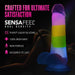 The Rainbow Rave Slim Glow in the Dark 6.5 Inch Silicone Dildo stands upright, showcasing bold rainbow stripes, dual density, 100% body-safe non-porous silicone, harness compatibility, and a durable design against a dark background.