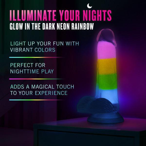 The Rainbow Rave Slim Glow in the Dark 6.5 Inch Silicone Dildo features vivid neon pink, yellow, green, and blue bands, stands upright, is harness compatible, and glows for colorful fun during adventurous nights.