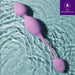 A purple Raine Vibrating Kegel Ball with Remote Control floats in rippling water; its two oval silicone shapes connected by a slender stem showcase IPX7 waterproofing, promising convenient kegel exercises.