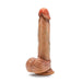 The Raphael Ultra Realistic 9.5 Inch Silicone Dildo with Sliding Foreskin in Caramel by Blush features a pronounced head, veiny texture, and a pronounced base resembling testicles. It stands upright on a flat surface and is also strap-on compatible.