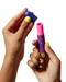 Romp Lipstick Pleasure Air Clitoris Stimulator Vibrator pink and blue in model's hand with lid off 