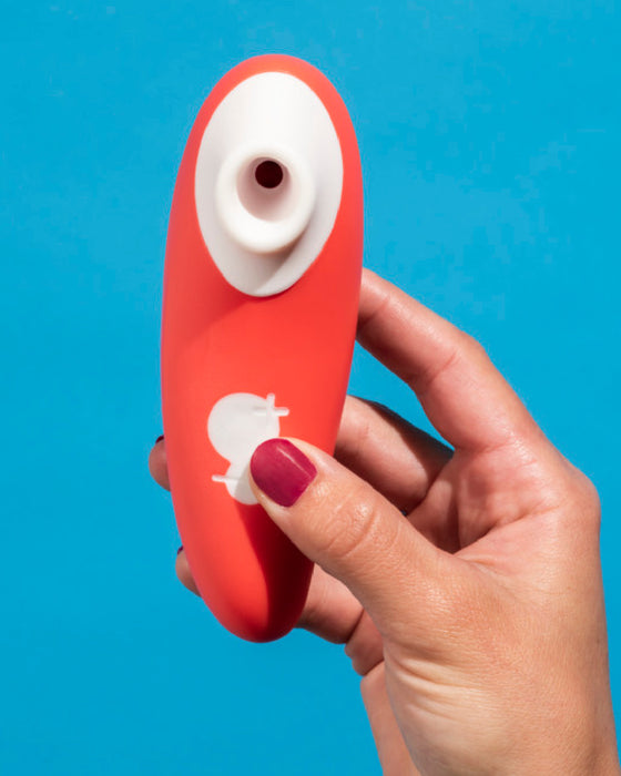 Switch Beginner's Pleasure Air Clitoral Stimulator in model's hand with blue background 