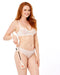 A woman with long red hair, in a sheer white bra and light underwear, smiles against a white background while holding the Peaches 'n Cream Impressions Crop.