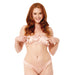 A woman with long red hair smiles at the camera, wearing a light pink satin bikini and elegant Peaches 'n Cream Pearl Nipple Clamps with Bells, standing against a plain white background.