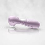 A Satisfyer Pro 2 Waterproof Pressure Wave Clitoral Stimulator in lilac rests on a light grey, reflective surface.