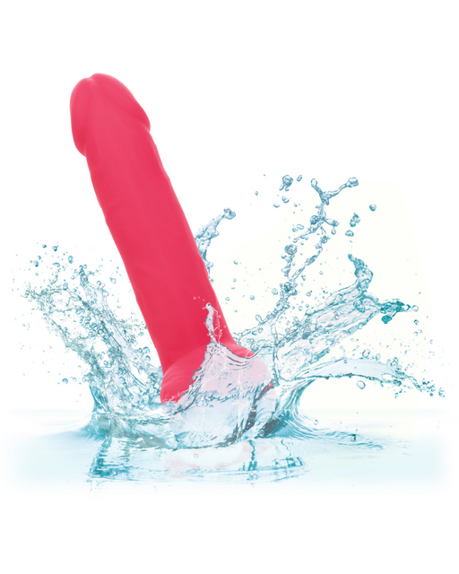 A neon-hued delight, the CalExotics Silicone Stud 8 Inch Suction Cup Dildo - Pink splashes into the water against a white background, creating visible water droplets and ripples around the toy.